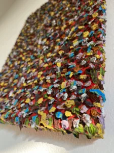 Gum Wall Tactile Textured Squeeze — abstract oil-and-wax painting; hundreds of piped impasto dabs in yellow, blue, white, green and brown covering a red ground — detail 2 of 3, close-up of surface texture